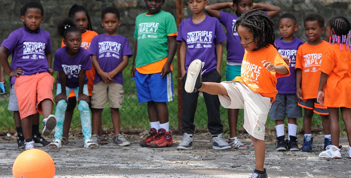 young children with Triple Play t-shirts playing ball