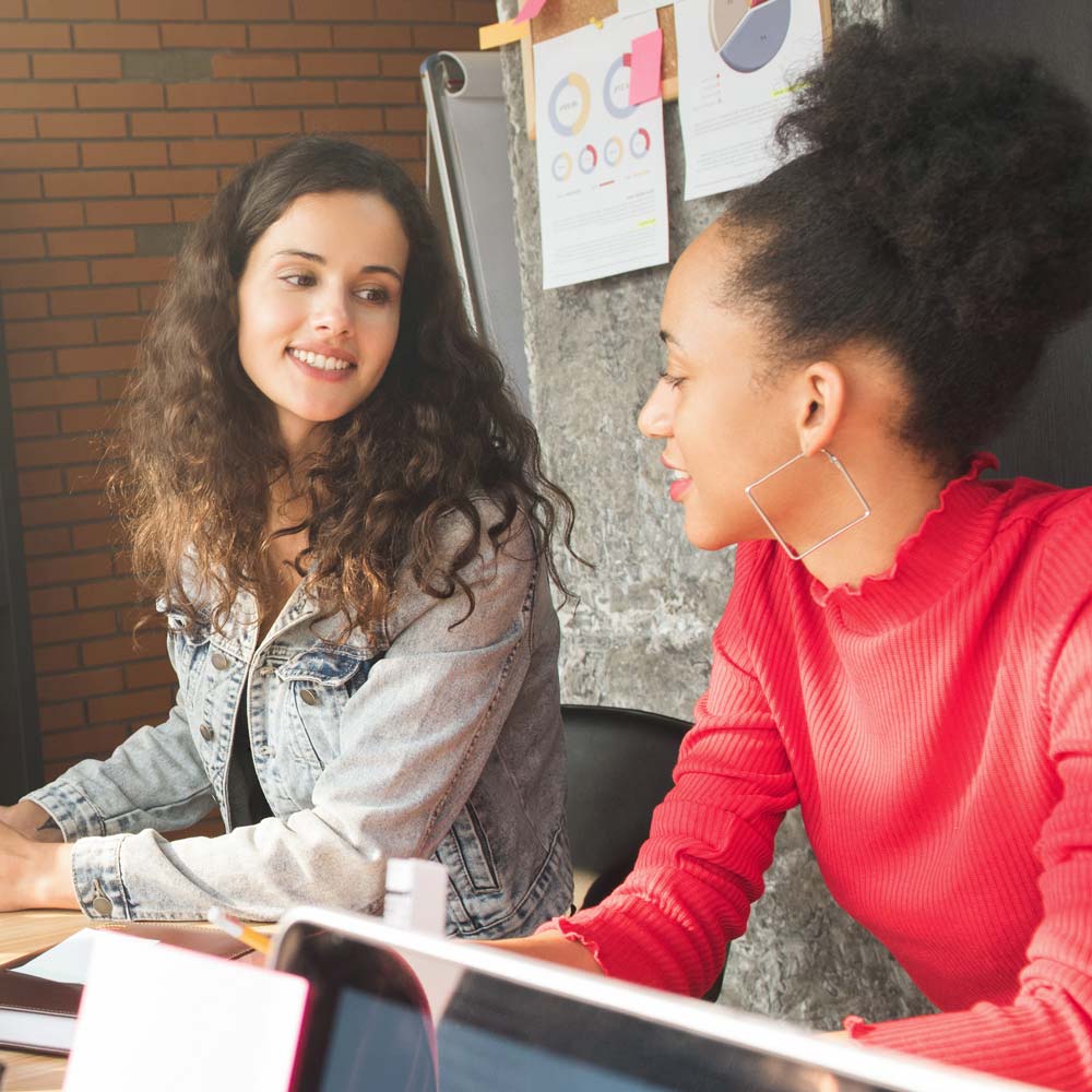 two people talking at a desk