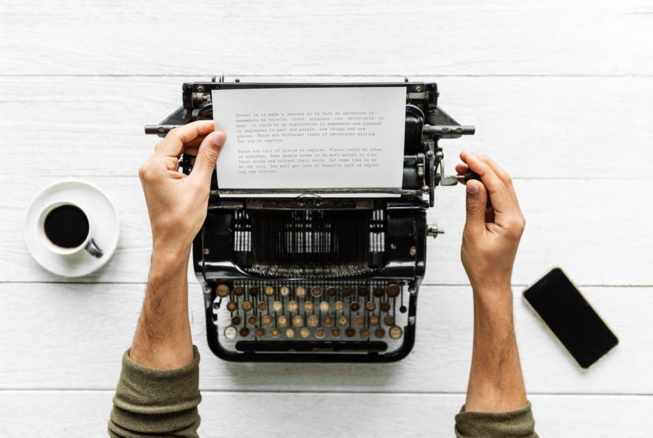 person typing on typewriter