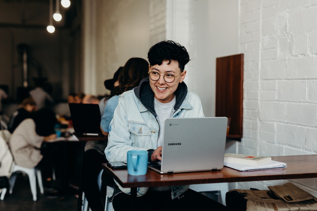 man working on computer in coffee shop