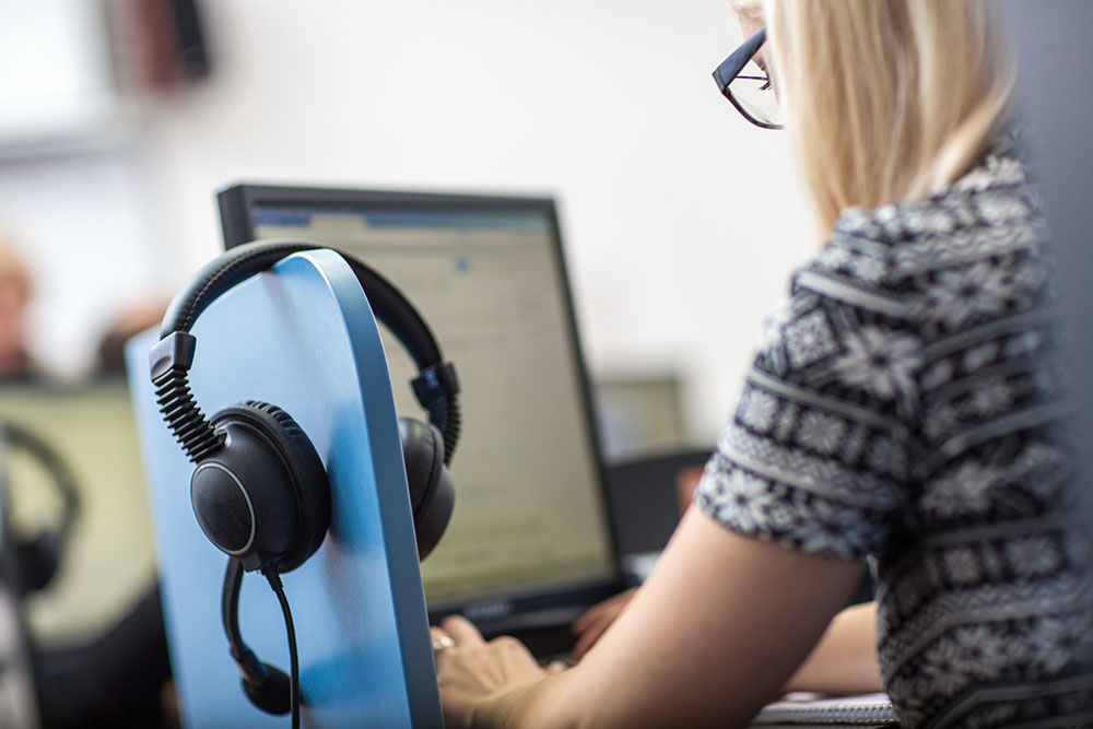 woman on computer with headphones 