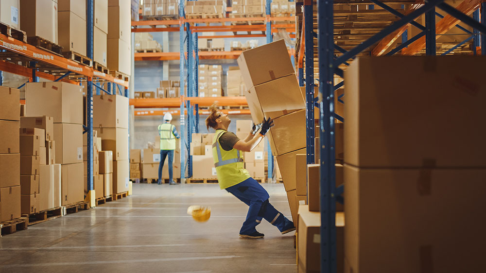 boxes falling on man in warehouse